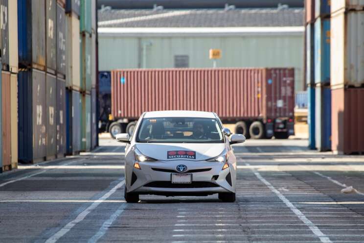 Mobile Guarding driving past shipping containers at the port.