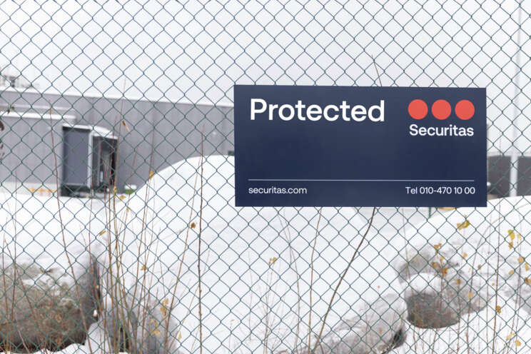 Securitas sign displaying the text, "Protected" on a gate.
